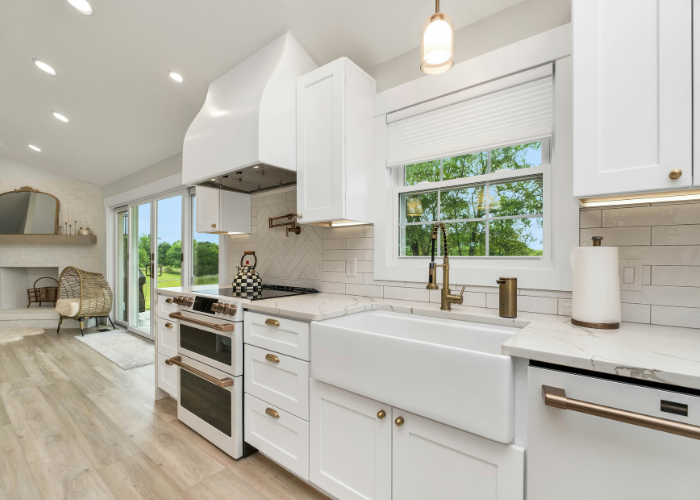 Renovated kitchen with white cabinets, farmhouse sink and brass fixtures